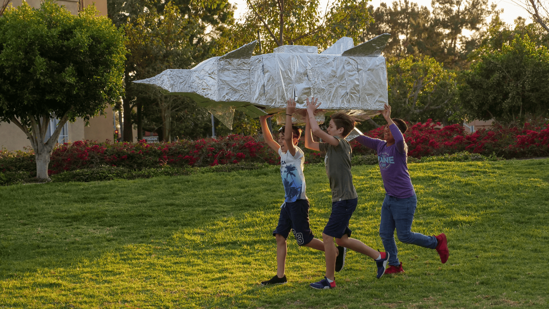 three kids running with tinfoil spaceship
