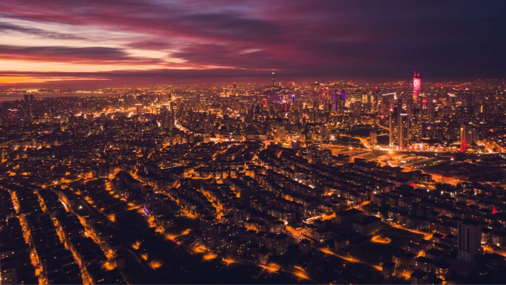Large city with lights as the sun sets