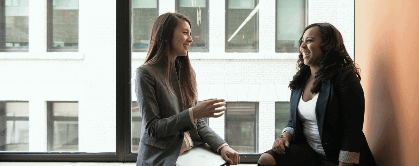 two women sitting by window in office