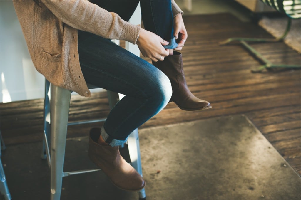 woman pulling on boots