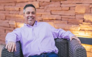 A photo of Avetta CEO John Herr sitting on a large wicker chair