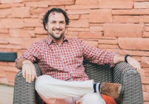 A photo of PICS/Avetta Co-Founder Jared Smith sitting on a large wicker chair