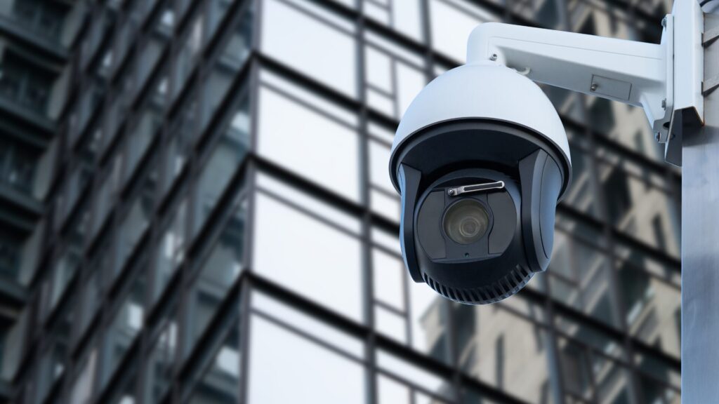 Photo of a surveillance camera mounted on a building in a city setting